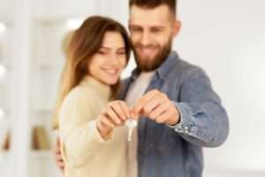 New Home Owners. Young Couple Holding House Key