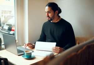 Startup, research or business man on laptop in coffee shop for strategy planning, life insurance or